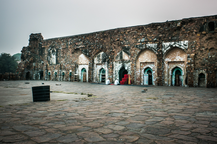 Two men paying homage to the Jinn in the ruins of the Feroze Shah Kotla Fort.