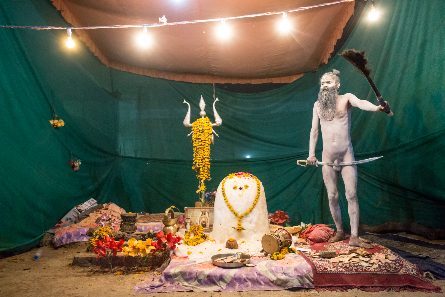 Naga Sadhus have matted locks of hair and cover their bodies in ash to look like Lord Shiva, who was a "black" Indian. Naga Sadus are spiritual descendants of an ancient warrior class formed to protect Hindus from Islamic invaders and some Naga Sadus affix a sword through their genitals as an ascetic practice.