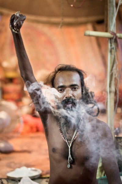 This sadhu, imbibing a joint, says he has kept his hand raised for six years. You can observe that his raised hand is deformed. Sadhus take on such ascetic assignments, which fall under the yogic practice of pratyahara o r "sensory withdrawal," to prove their devotion. 