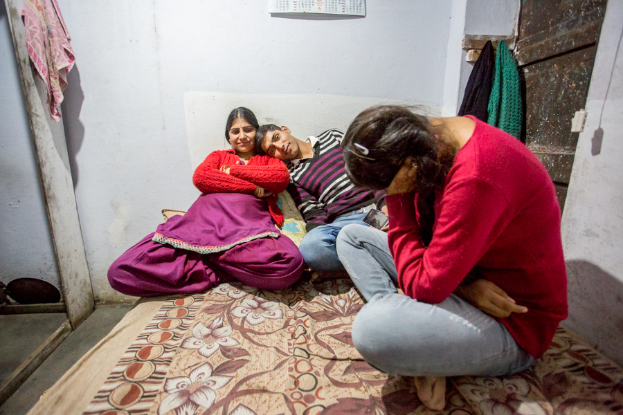 The Herr family hanging out on their bed (in which Miri and Lovely seep -- Arun sleeps on the floor), which also doubles as their dining table. 