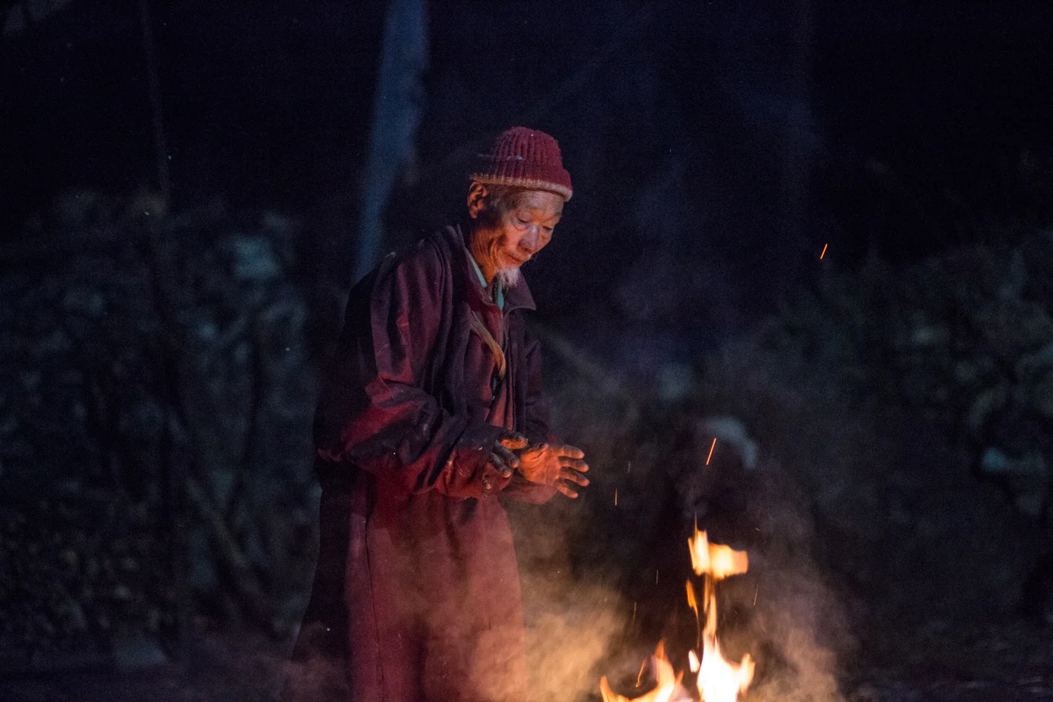 A villager keeps warm by a fire in the village of Namrung located in the Manaslu reserve. 