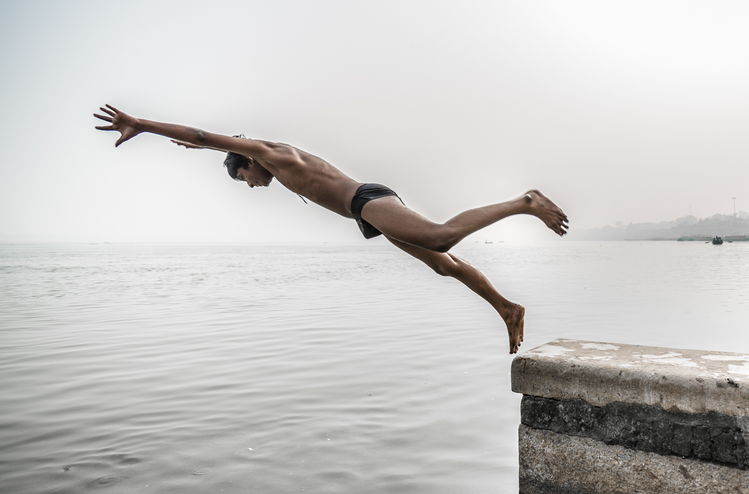 Boy jumping into the Ganges.