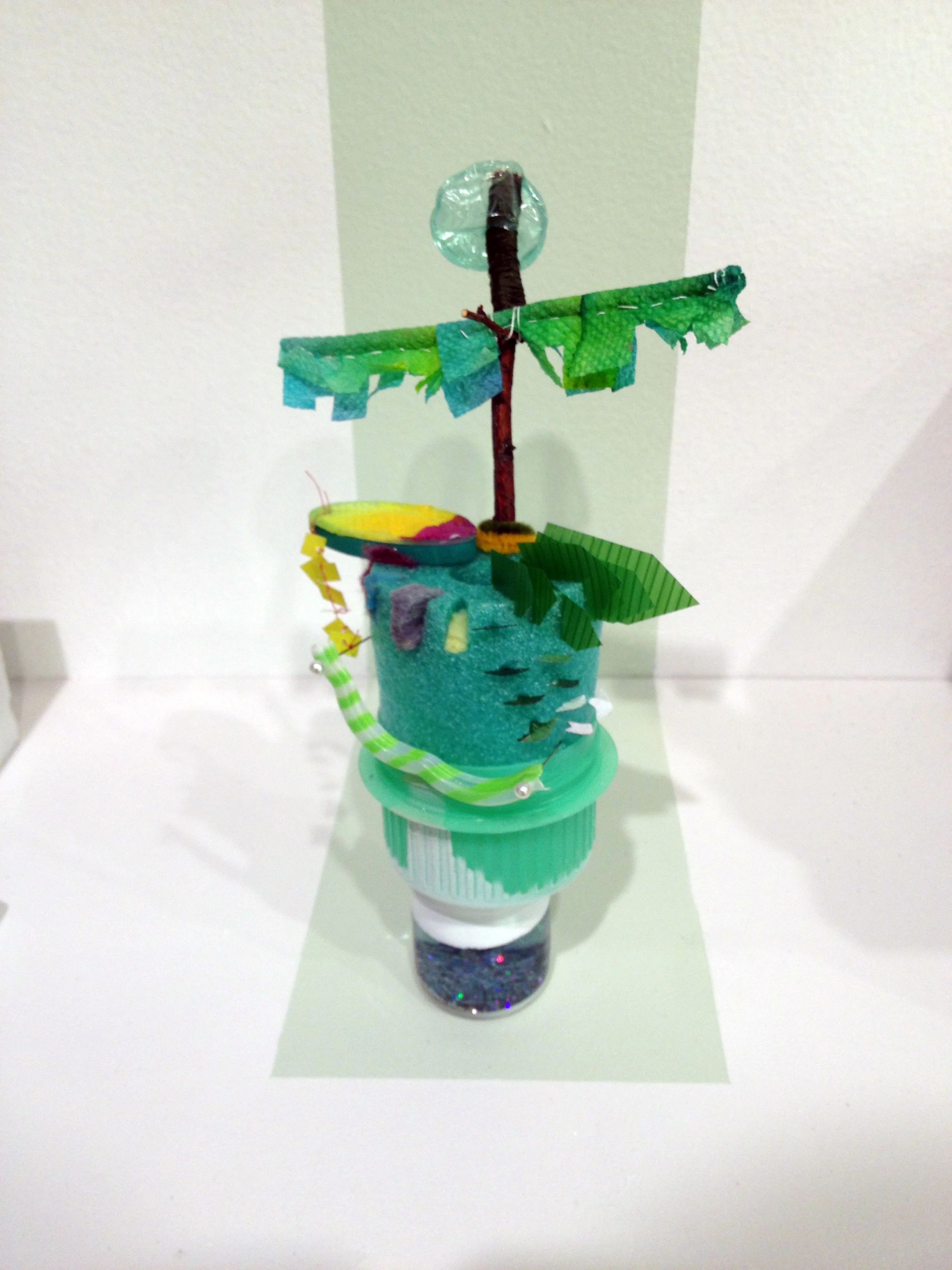A STORY ABOUT THE BEGINNING Detergent lid, branch, pipe cleaner, pool noodle, dyed paper towel, sushi grass, small jar, glitter, bubble wrap, star confetti, gelato cup 2015 7'' x 5'' x 3''