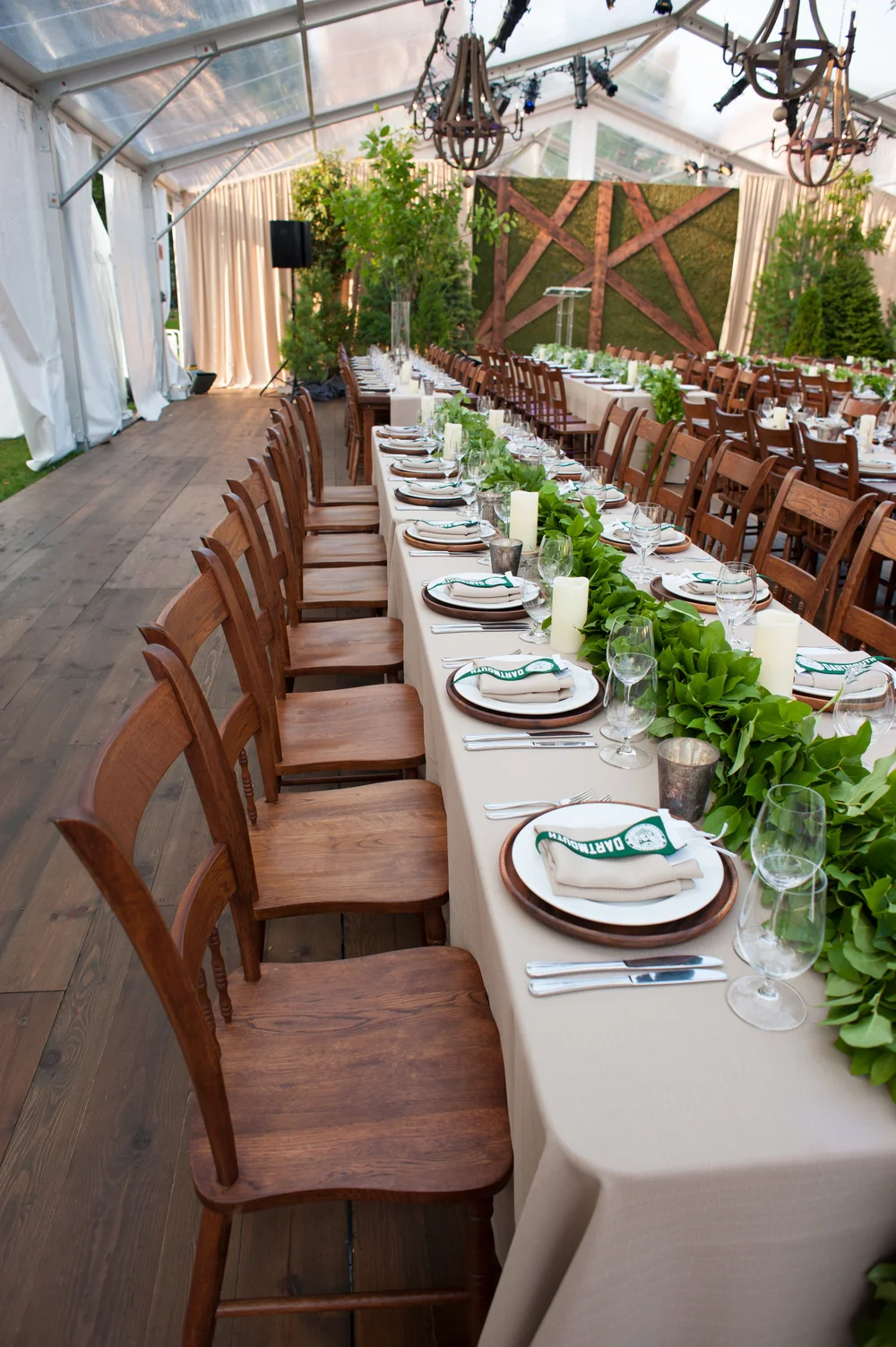 Farm table set with Dartmouth green place settings under a tent