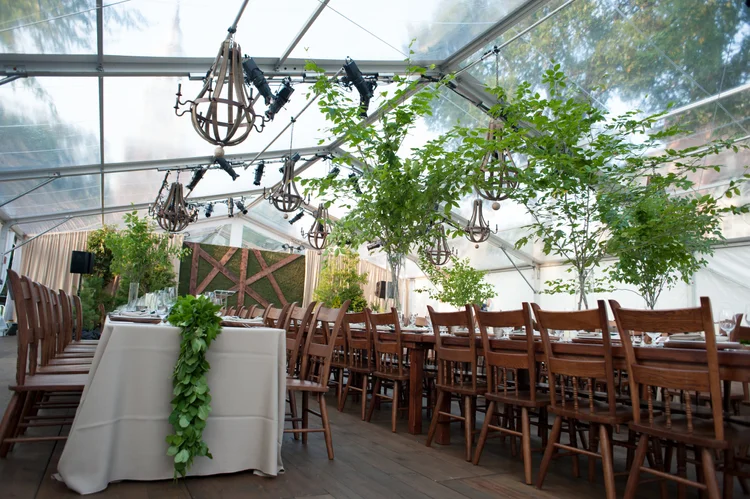 Chandeliers and greenery inside a clear top tent at Dartmouth College