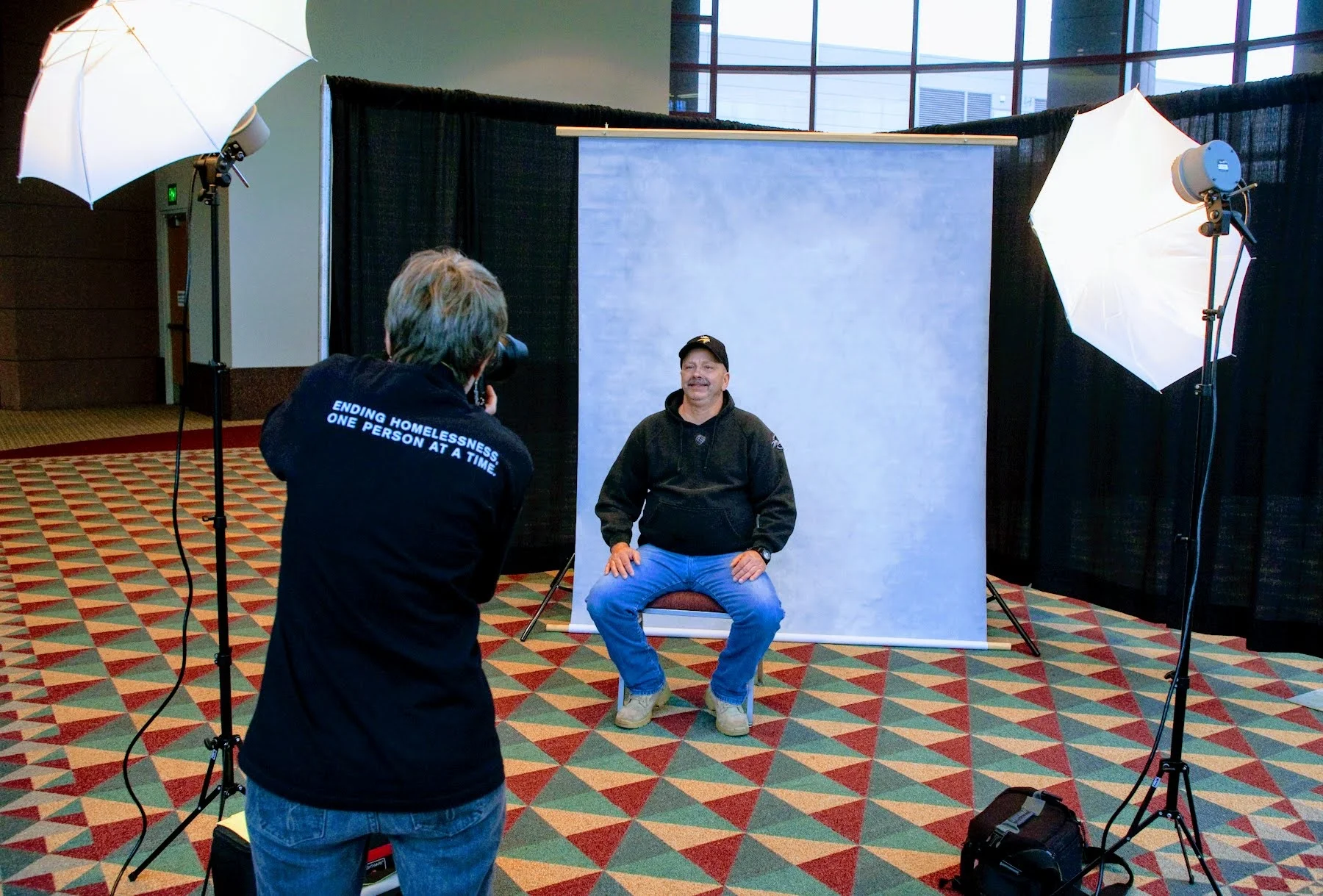 A man sits for a portrait by photographer Joey McLeister.