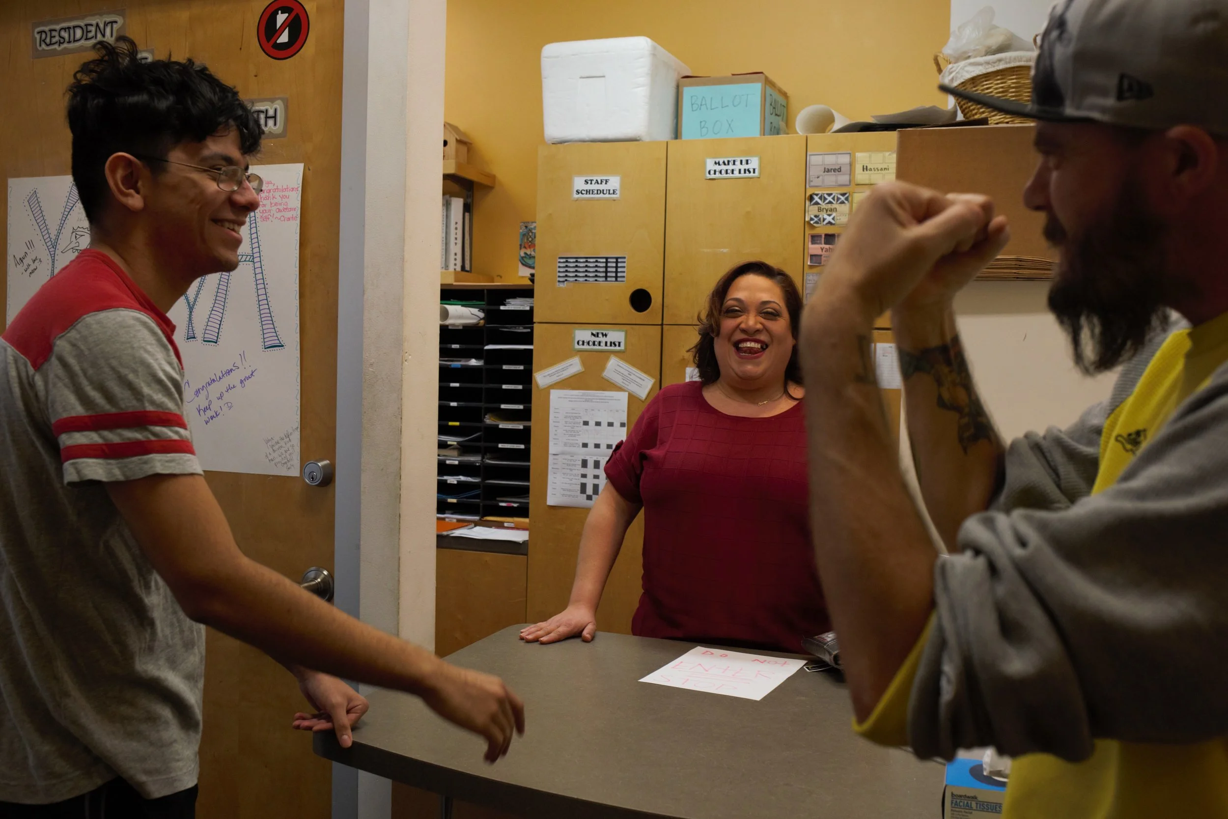 Program manager Beatriz Albelo laughs with residents of a supportive housing program for youth in Chicago.