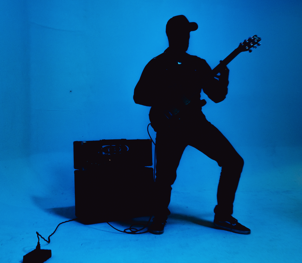 Silhouette of Khris Glaring performing on stage with blue stage lighting