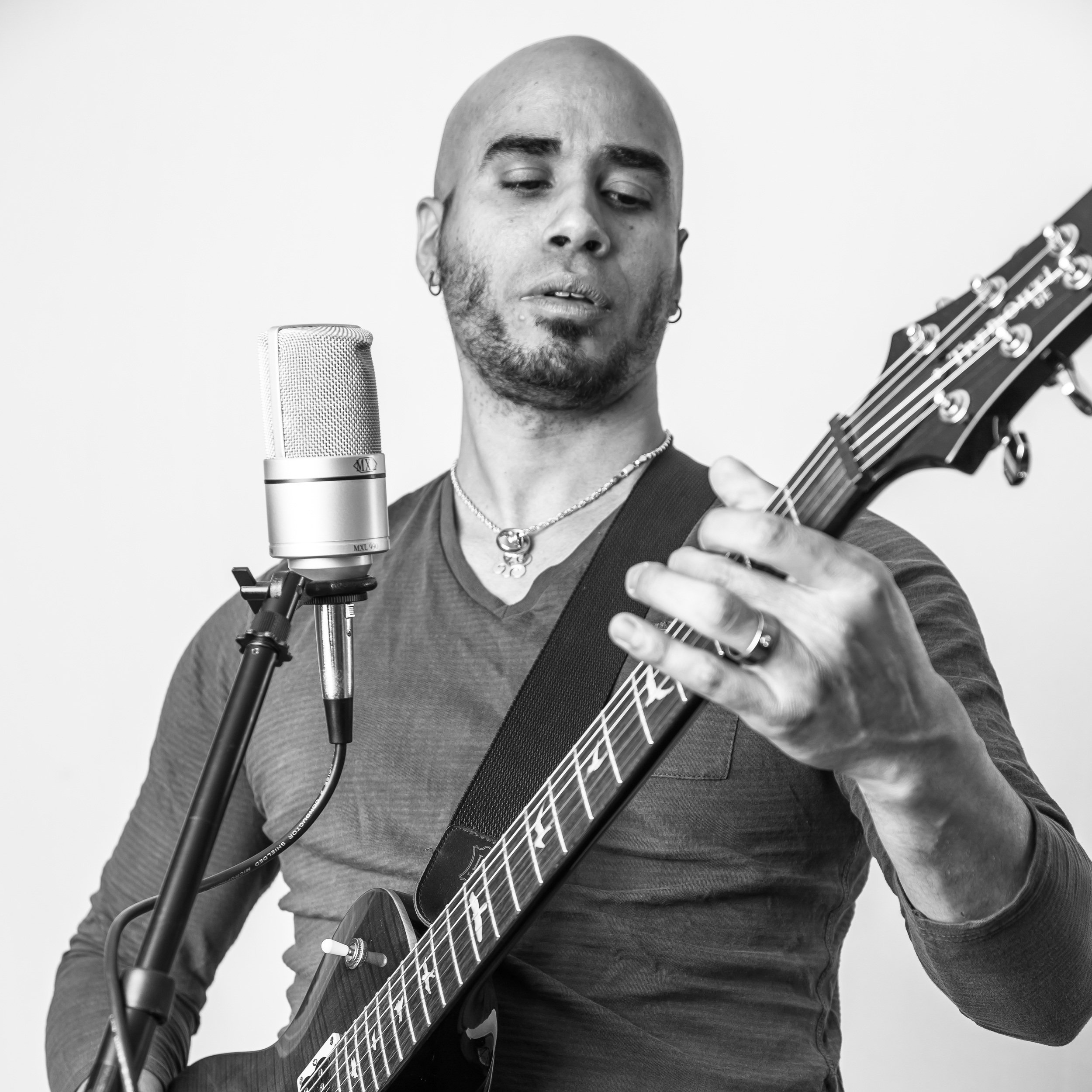 Khris Glaring performing live with an electric guitar and microphone