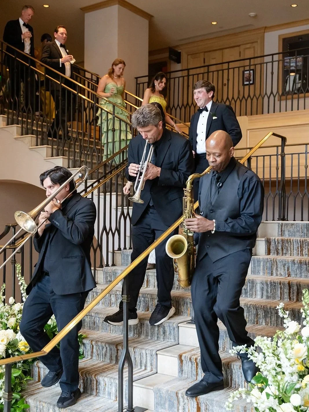 Second line band leading wedding guests from cocktail hour to dinner during a seamless reception transition