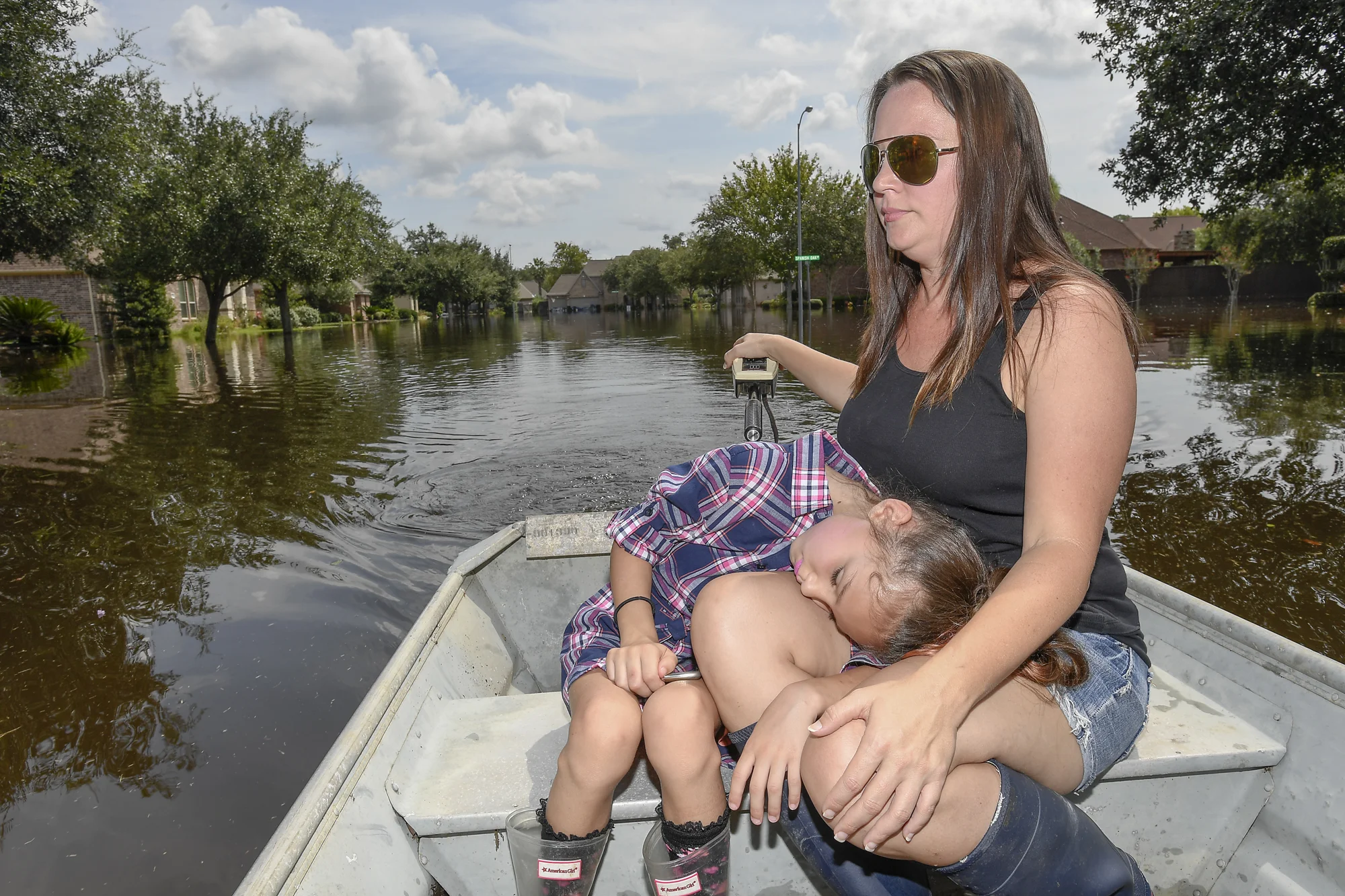 Dylan Borel, 7, rests her head on Mande Borel's lap Monday, Sept. 4, 2017, as she steers the boat through their neighborhood that flooded in Lake Jackson, Texas. 