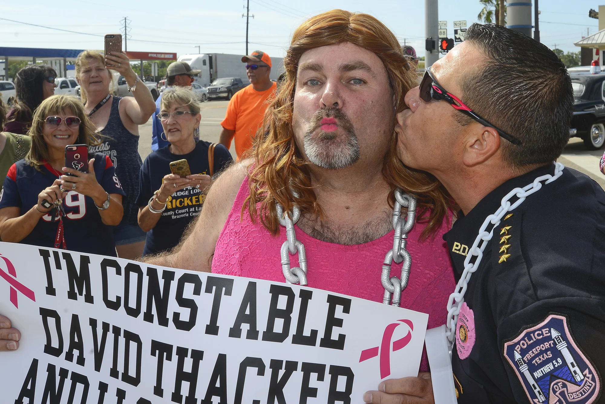  Freeport Police Department Chief Ray Garivey, right, gives Constable David Thacker a kiss on the cheek Tuesday, Oct. 9, 2018 on the corner of North Brazosport Avenue and North Gulf Boulevard in Freeport after Thacker lost a football bet. 