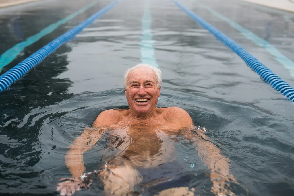 Klaus Obermeyer flashing a smile whiles swimming laps at the Aspen Meadows Resort in Aspen, CO