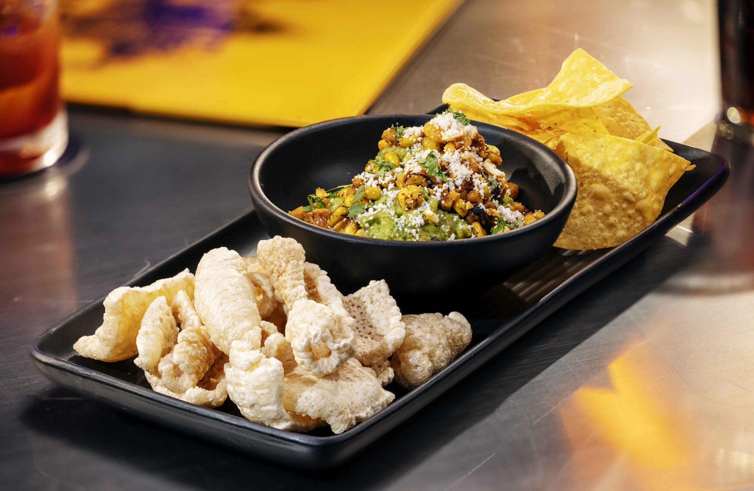 Guac Bowl $9.95 charred corn guacamole dip, tomatoes, chips