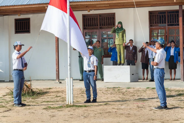 Ibu Ratna memberi hormat saat upacara bendera di sekolah.