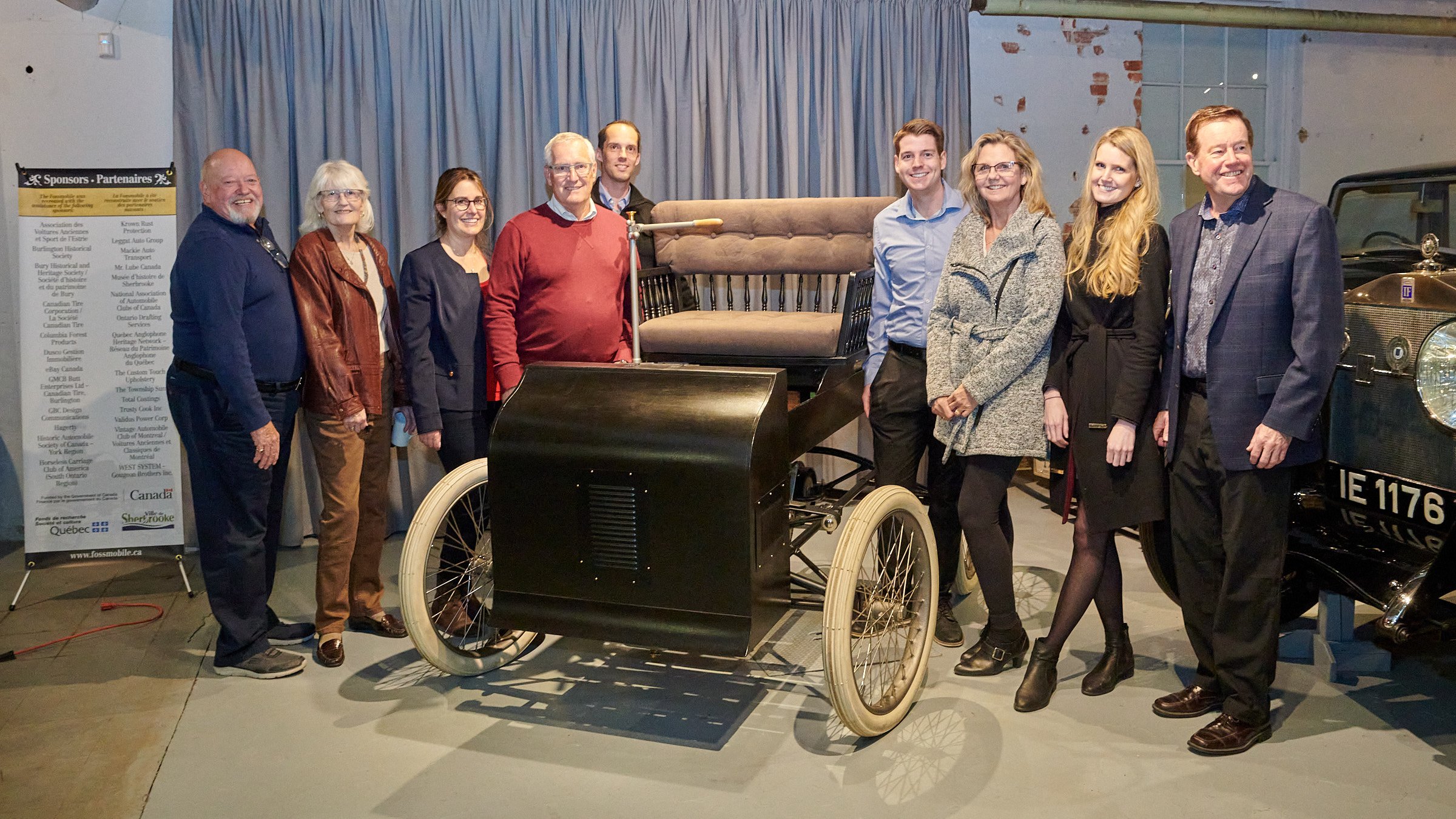  The Foss family, with Ron Foss in red at centre, poses with the replica Fossmobile. 