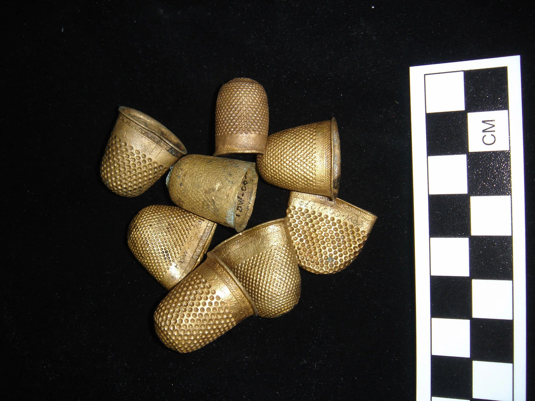 A collection of copper alloy gilt covered thimbles, which were part of the cargo, after ONPCS conservation