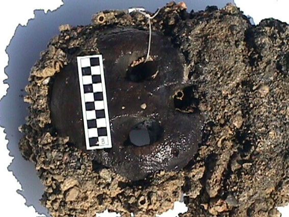  A concreted deadeye which was located in the bosun's store, with a rope thimble and silver coins attached to it 