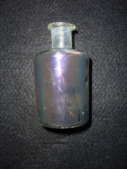 A flat bottomed glass perfume bottle