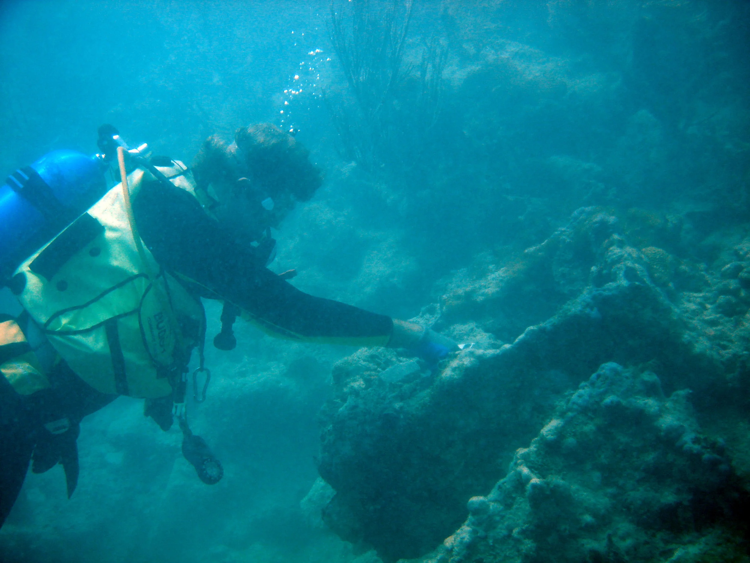 Dr. Spooner with an concreted iron box part of the cargo of the ship which is half way up the reef. This was originally buried but uncovered by looters when they destroyd the "Bottle Bank"