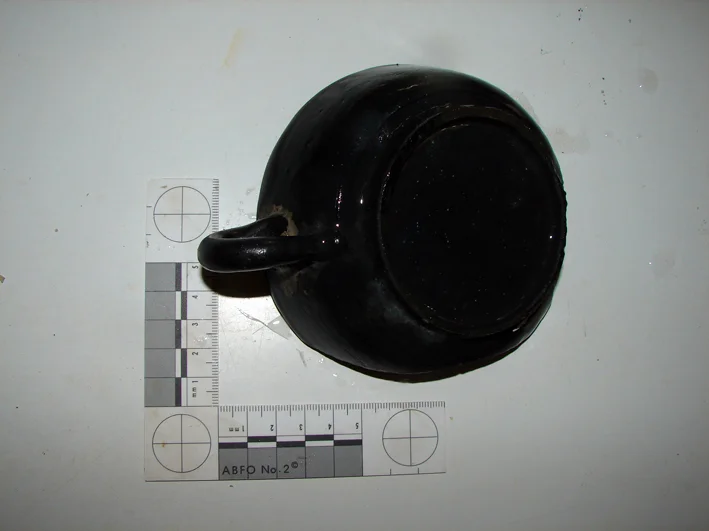The underside and showing the remaining intact handle
