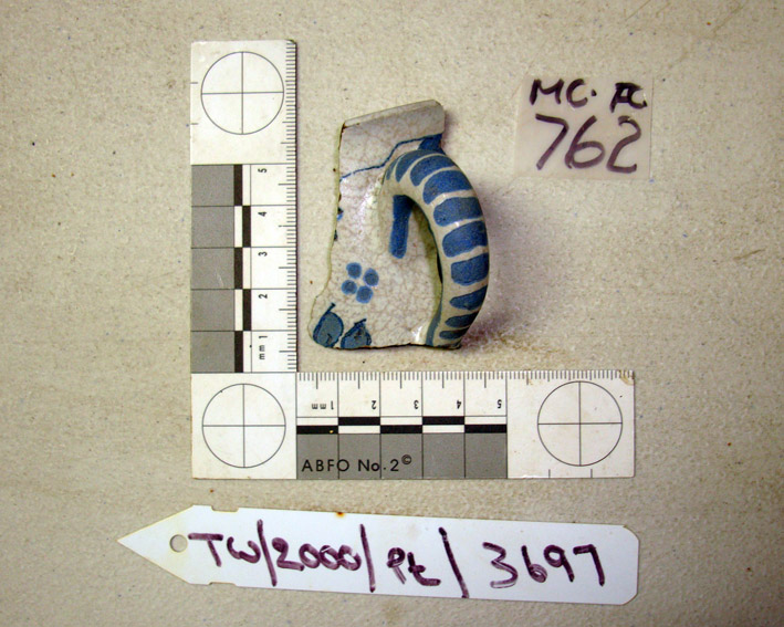   A French blue and white fainceware handle and part side of a mug, from     The Tile Wreck       at ONPCS, showing the two numbering protocols   