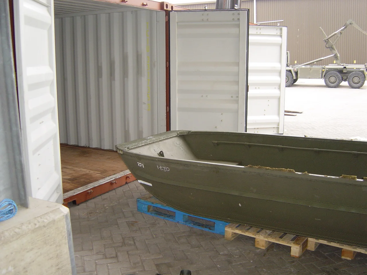 The first pontoon boat is gently slid into the container