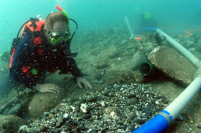 Amyas guards the dredge tail, making sure no small artefacts have been missed