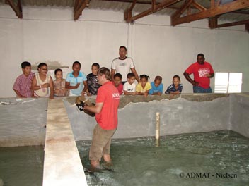 Simon showing the students a grinding wheel from The Faience Wreck up close while speaking in English, then Jonny and Rami translate into Spanish, making it a multi-discipline learning experience for the students.