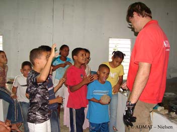 The students are eager to try holding a small concreted 4 pdr cannon ball from The Tile Wreck.