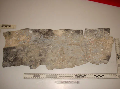 One of the lead patches. Note one side has been ripped off the other still shows the square nail holes. Interesting to see that the lead is concreted
