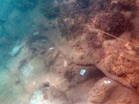 The ceiling planking can be seen on top of the floors and futtocks with the ballast stones on top