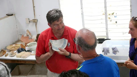 Dr Spooner showing a broken section of a barber’s bowl and explains why there is a special curve in the lip of the bowl