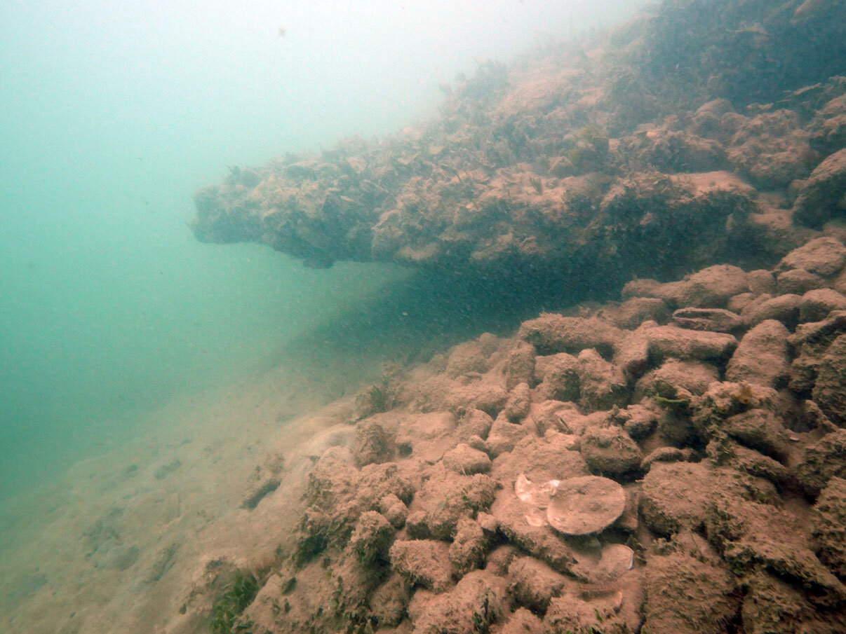 The starboard side looking towards the break with ballast stones in the foreground still on the hull planking.