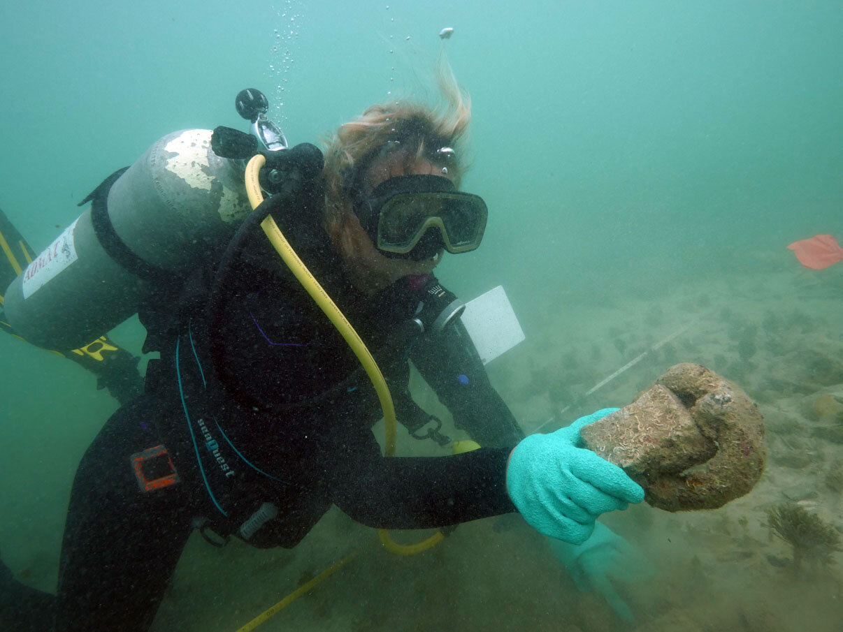 Dr Florence Prudhomme with an iron ring with a half brick from the galley attached by the forming of the concretion.
