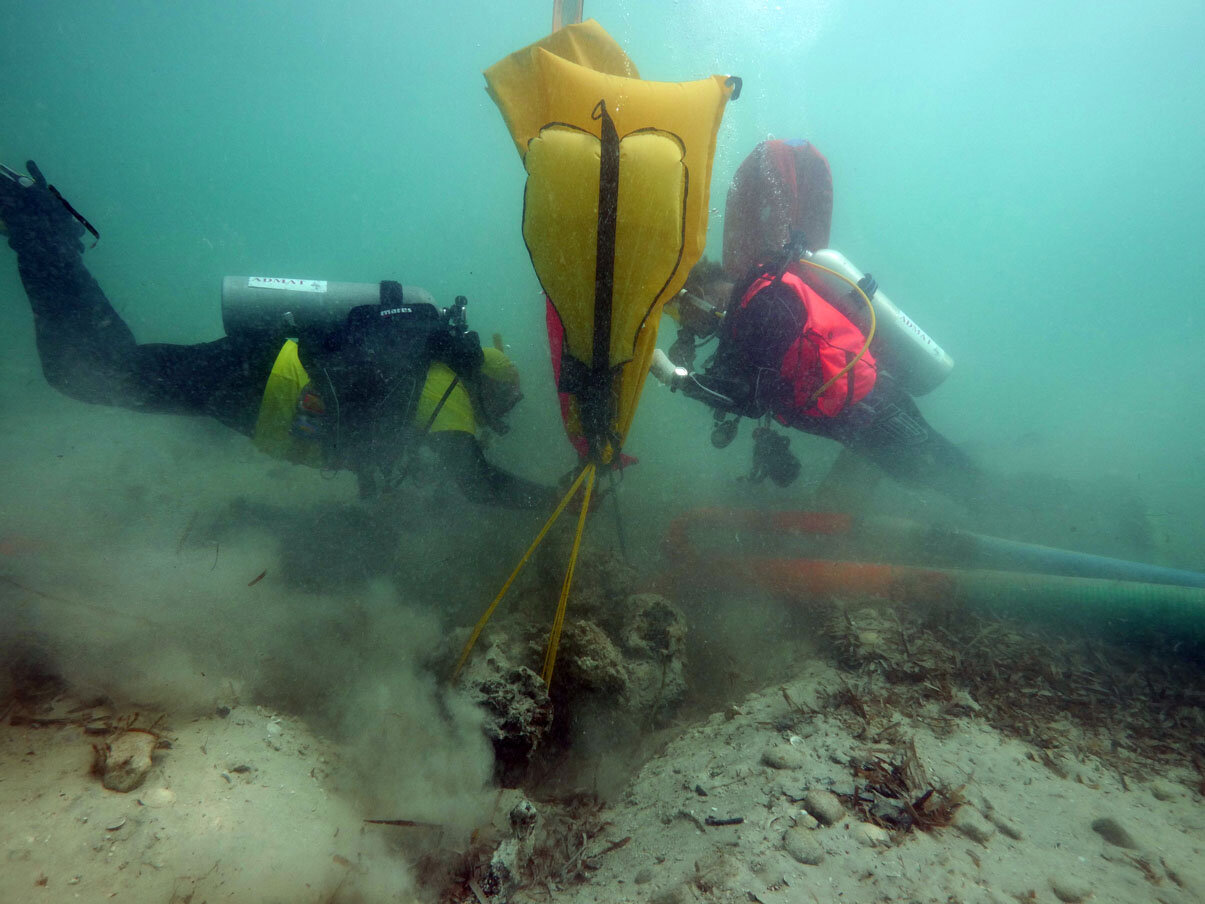 Lifting bags deployed to steady the heavy concretion while it is being uncovered.