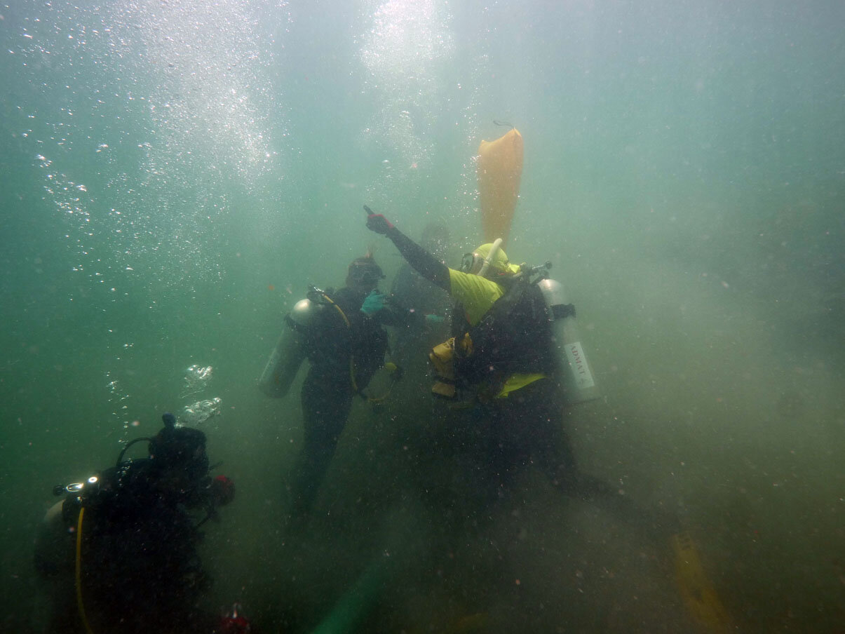 The Team relocating the concretion to the pile of iron ballast blocks. Once relocated the area will be surveyed again to check if there are any other ferrous artefacts.