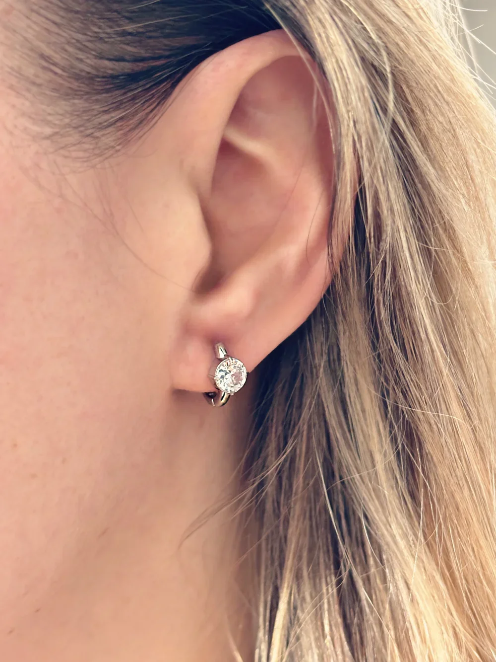 boucles d’oreilles en acier inoxydable brillantes portées à l’oreille