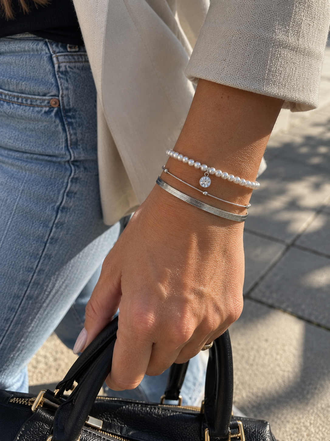 Bracelet Tamia trois rangs argenté avec perles et breloque brillante porté au poignet