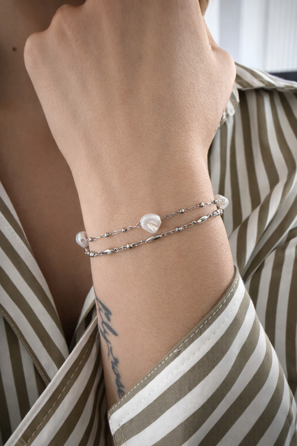 Bracelet argent et perles porté sur un poignet.-Tokade