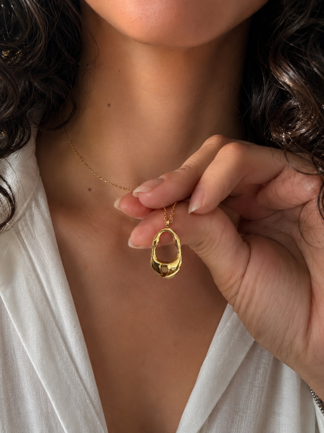 Femme portant le collier Galos en acier inoxydable doré avec chemise blanche - Tokade