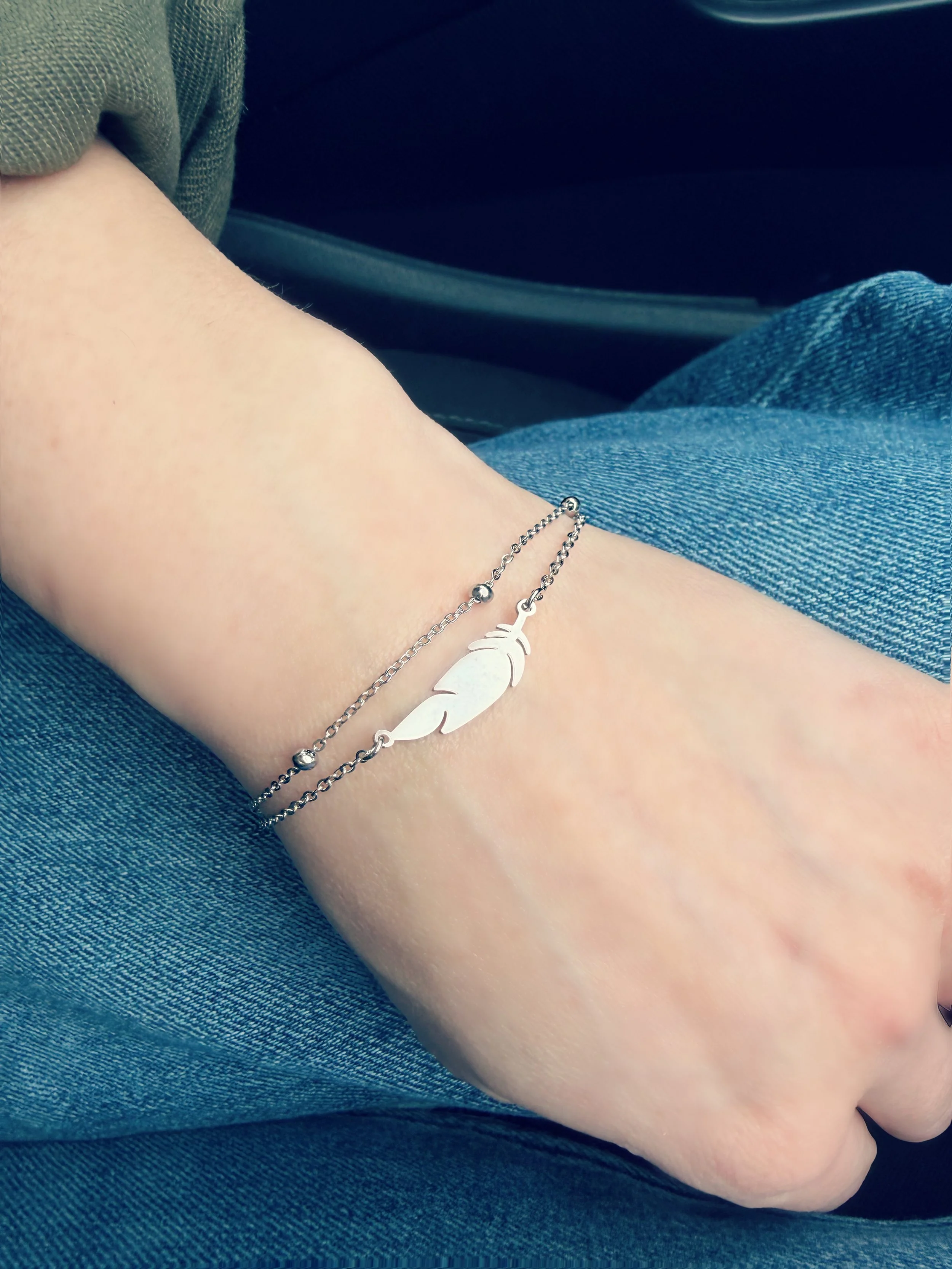 Bracelet délicat avec pendentif plume sur la main-Tokade