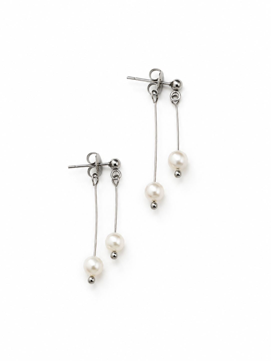 Boucles d’oreilles Veda argentées en acier inoxydable avec deux perles blanches sur fond blanc