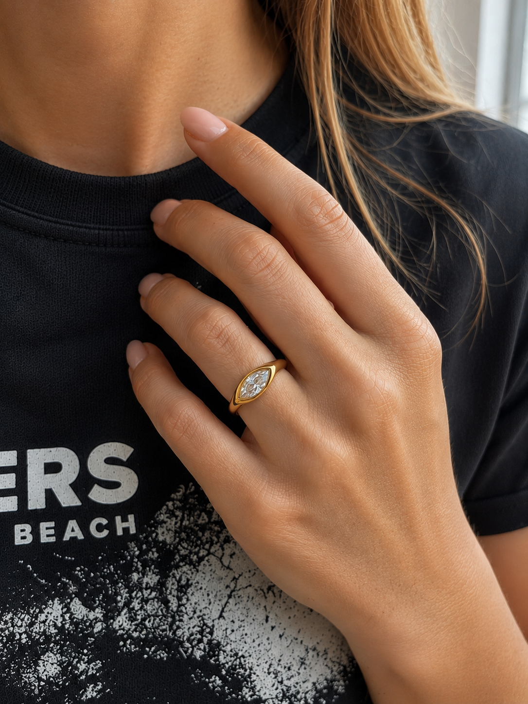 Bague dorée Ara avec pierre marquise portée avec une tenue noire
