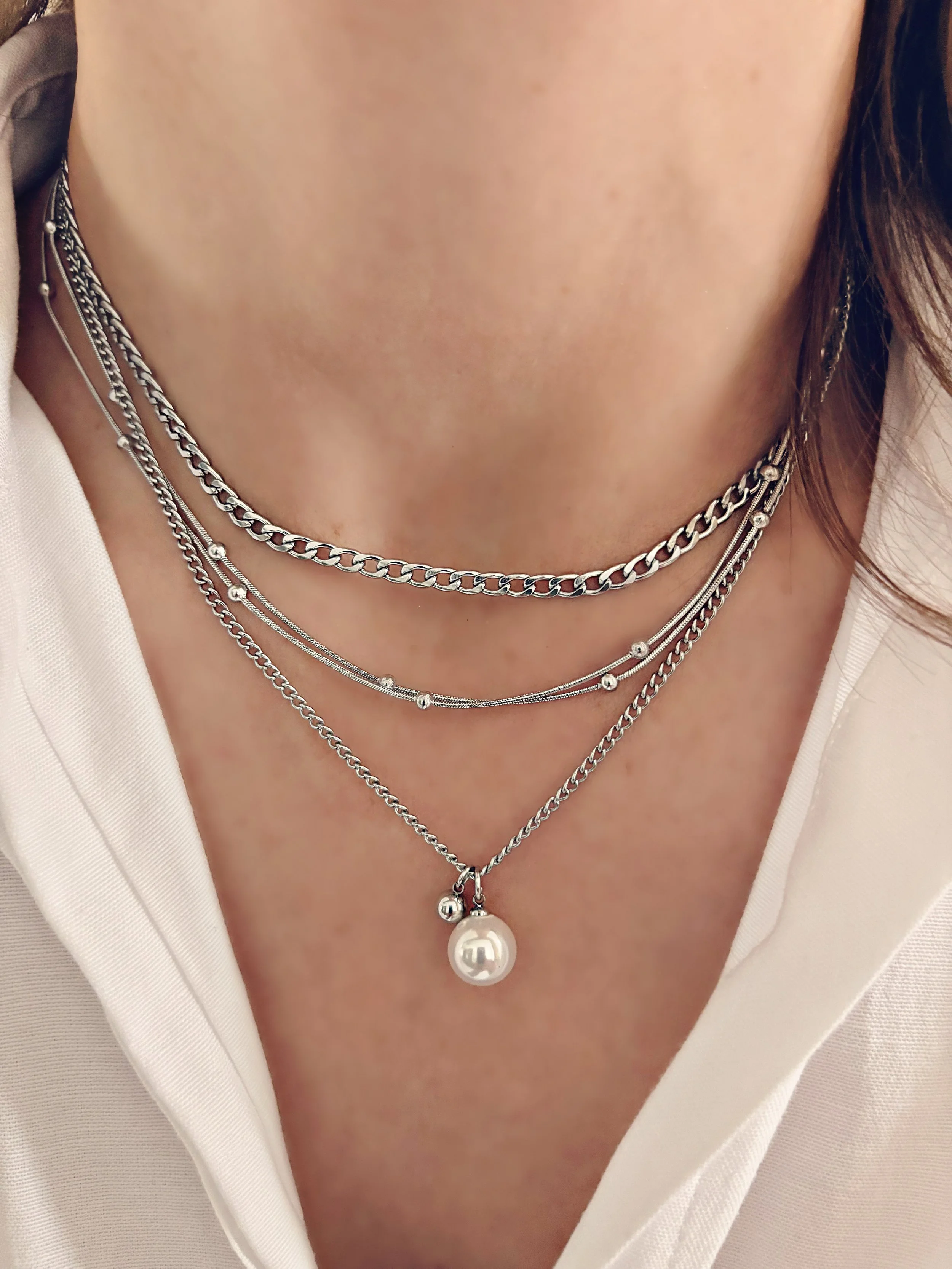 Collier Maelis porté, mettant en valeur les quatre rangs et le pendentif perle sur une tenue décontractée.