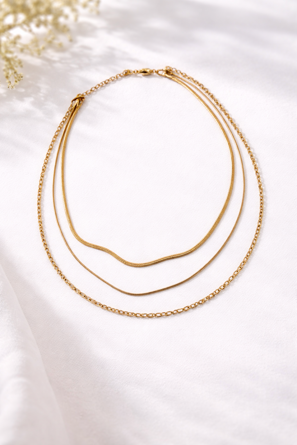 Collier multi-chaînes doré présenté sur une coiffeuse