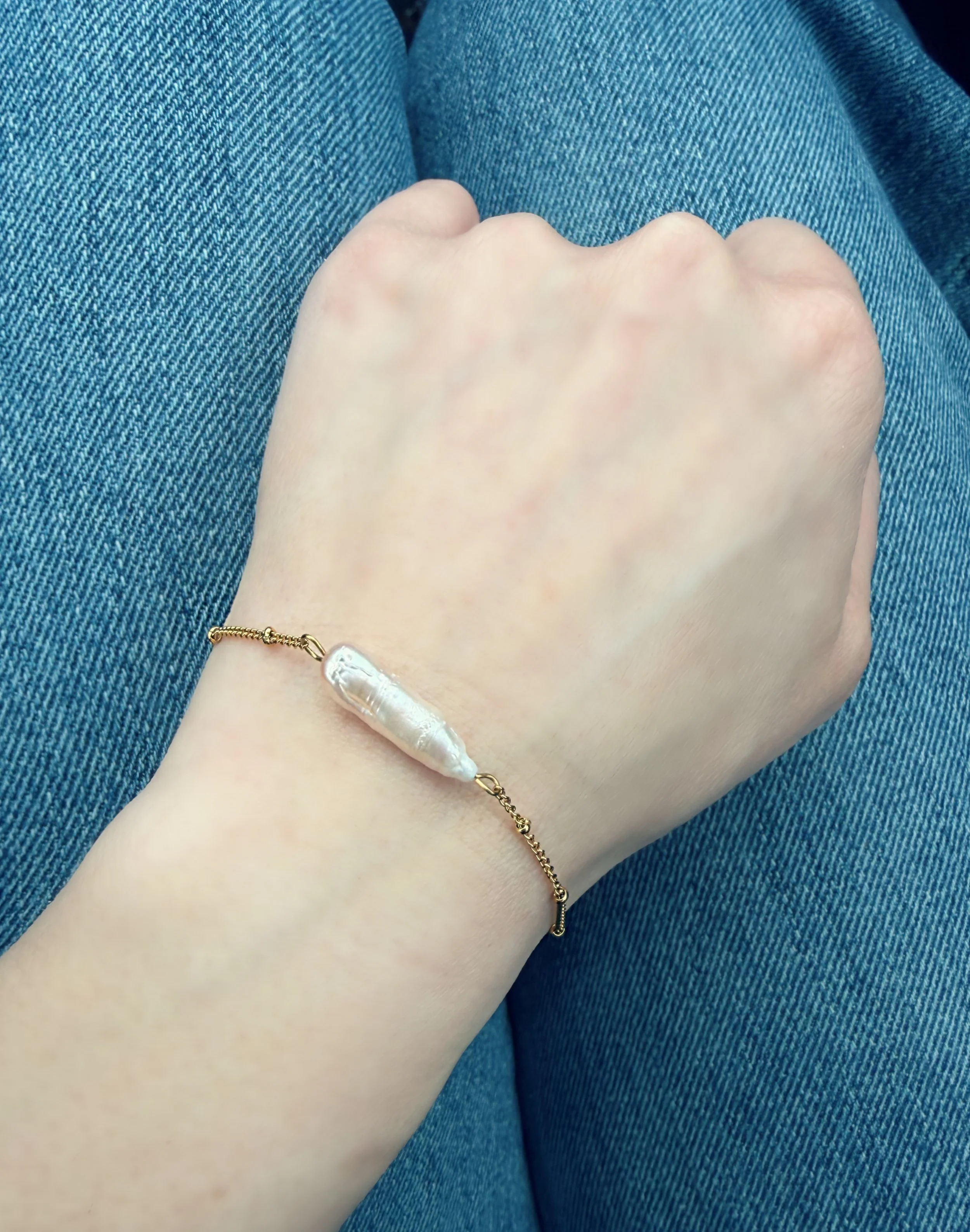 Bracelet avec perle baroque porté au poignet sur fond denim-Tokade