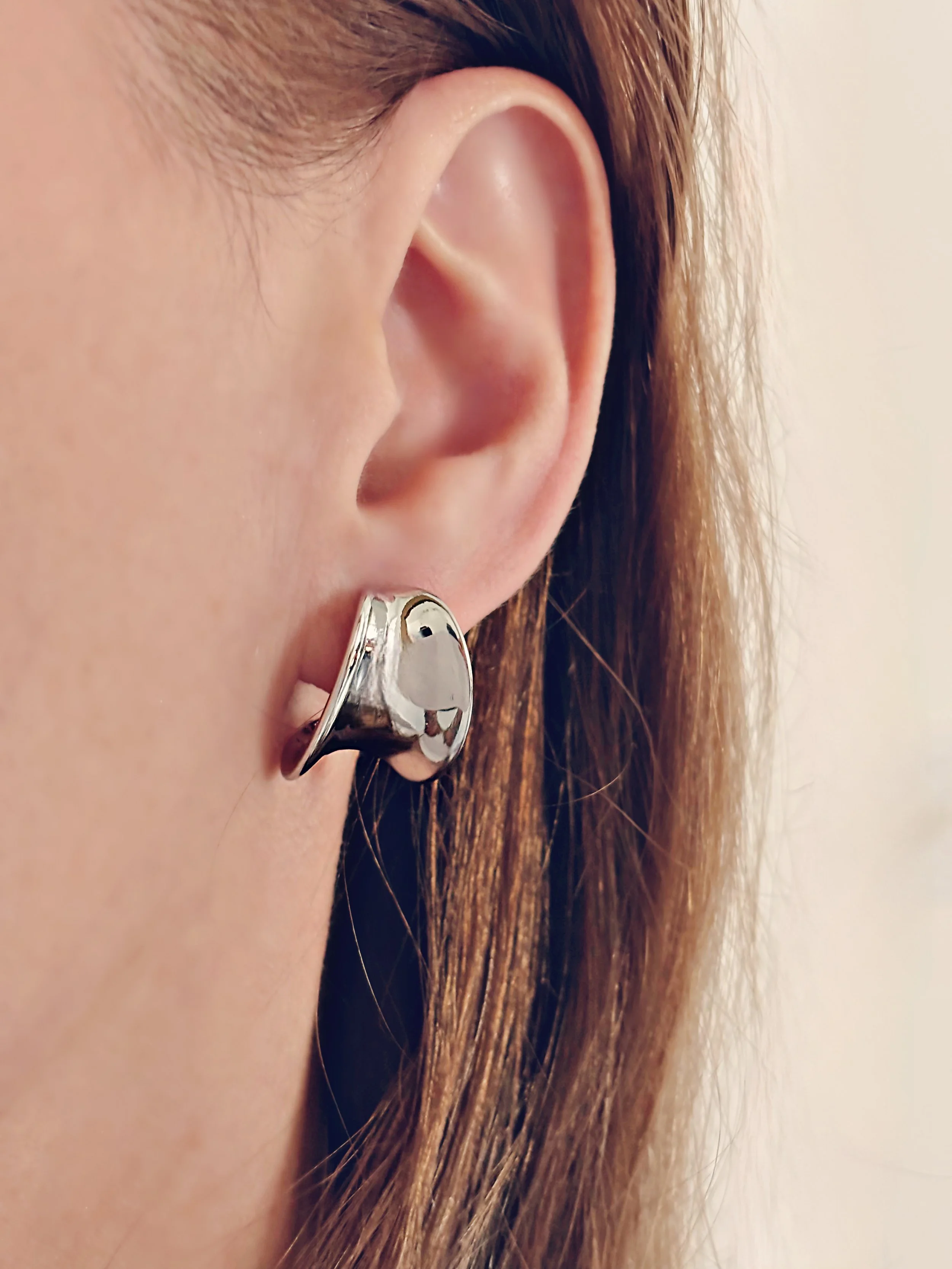 Boucles Mila portées, mettant en valeur leur effet miroir et leur brillance.
