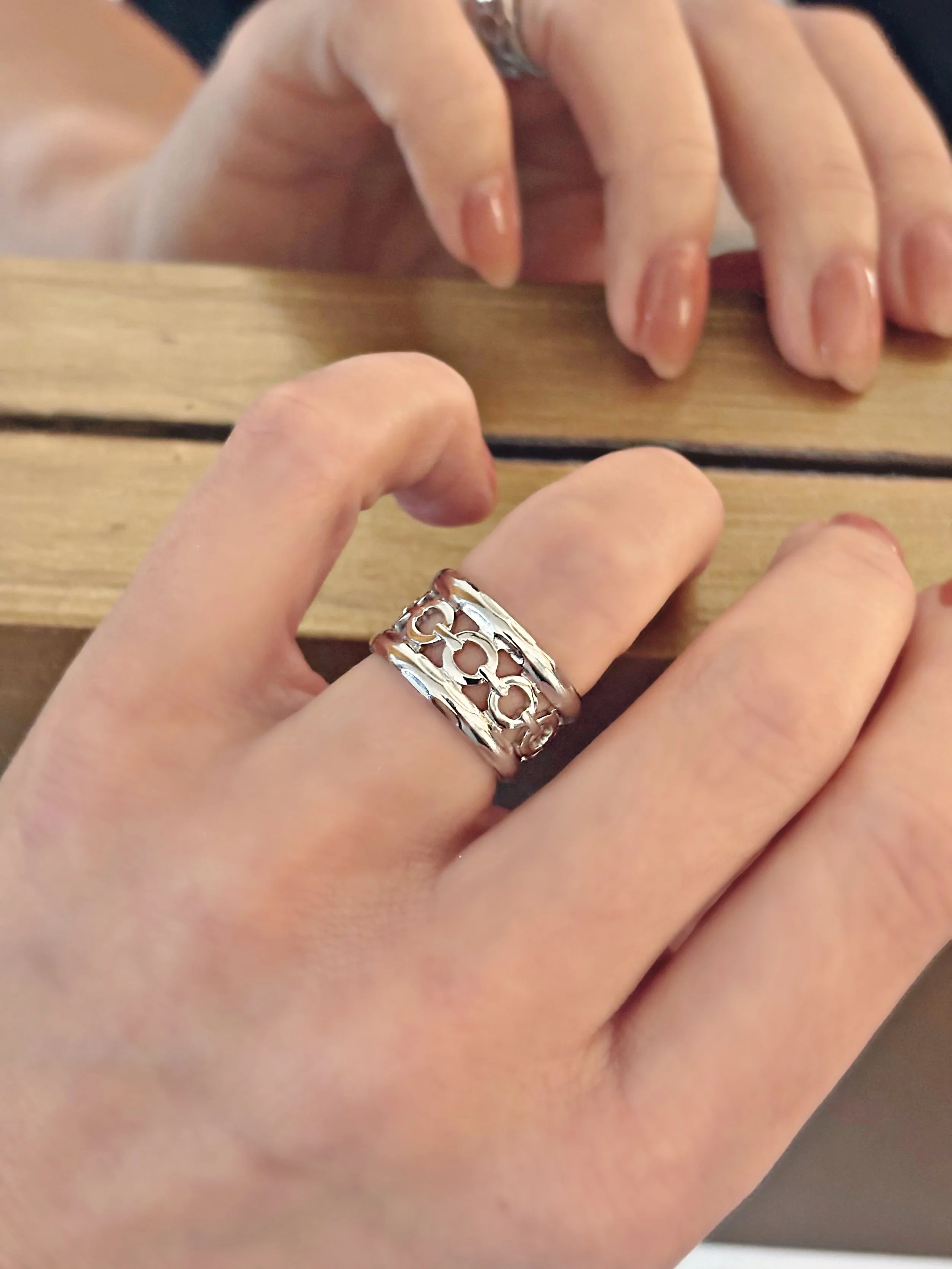 Bague Noelia en argent portée au doigt devant un miroir