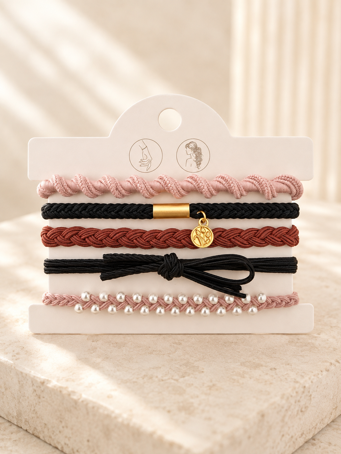 Lot de 5 élastiques à cheveux et bracelets 2-en-1 rose poudré, terracotta et noir avec perles, médaillon gravé et détails dorés.